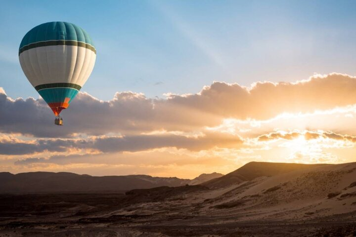 Lift off into a serene desert morning witnessing the sun rise over golden sands and enchanting oases creating unforgettable memories high above Dubai's breathtaking landscape.